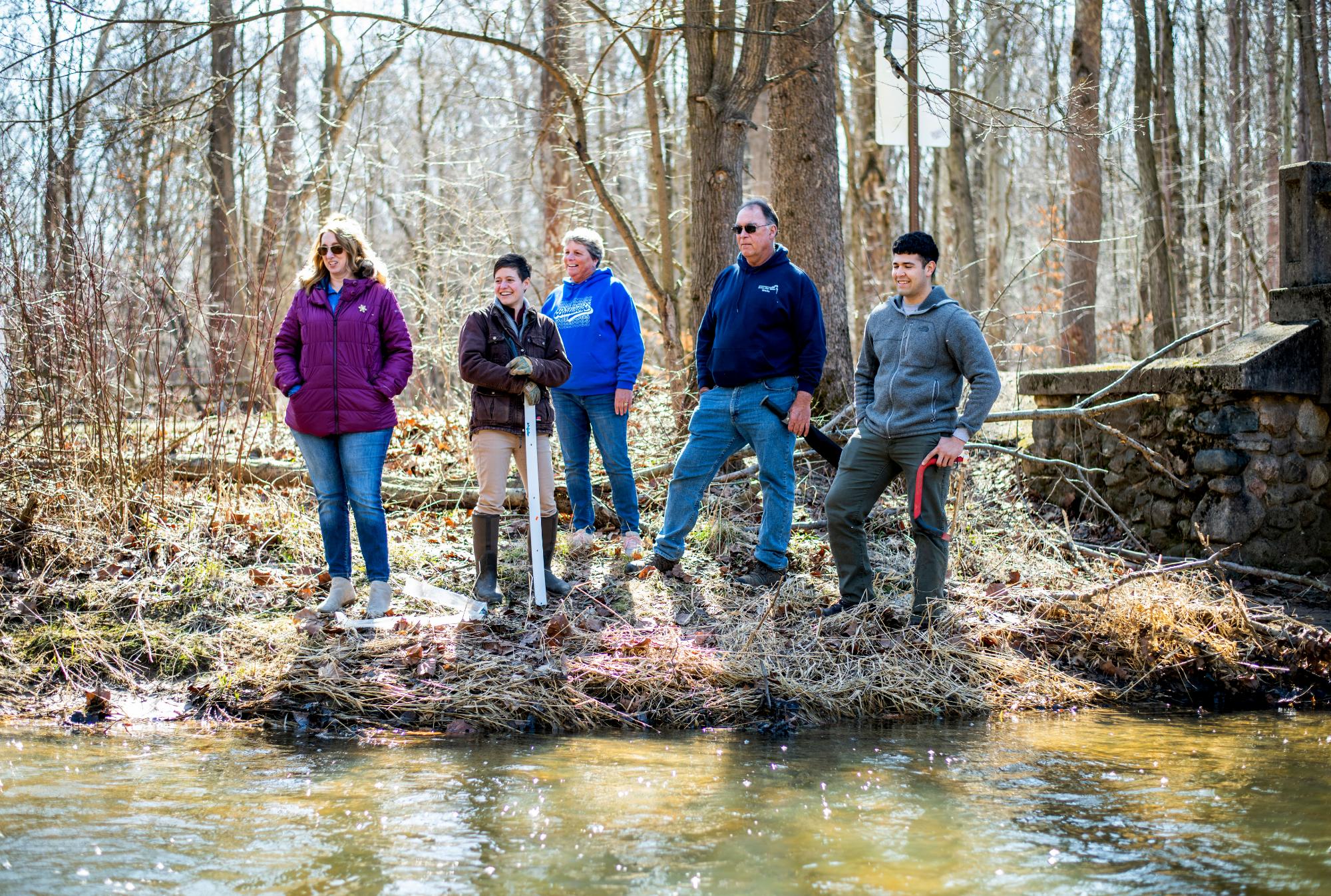 Students at the edge of a creek with a profession